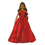 A doll with long black hair wearing a strapless red gown with a large bow at the waist, shown against a plain white background.