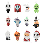 Twelve small hanging ornaments shaped like cartoon horror and holiday characters arranged in a 3-by-4 grid on a plain white background. The characters include black-and-white skull-like figures, a red-haired figure, a white ghost with an orange nose, a green monster, a pink devil, a pale blue witch, a green skull-faced figure, a black-hatted orange-faced figure, a white skull figure with glasses, a jack-o'-lantern, a Santa figure, and a white skull figure in red and black.