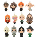 Twelve small character-shaped hanging keychains or charms arranged in a 3-by-4 grid on a plain white background. Each figure has a loop at the top and a short chain, with stylized cartoon faces and different outfits.